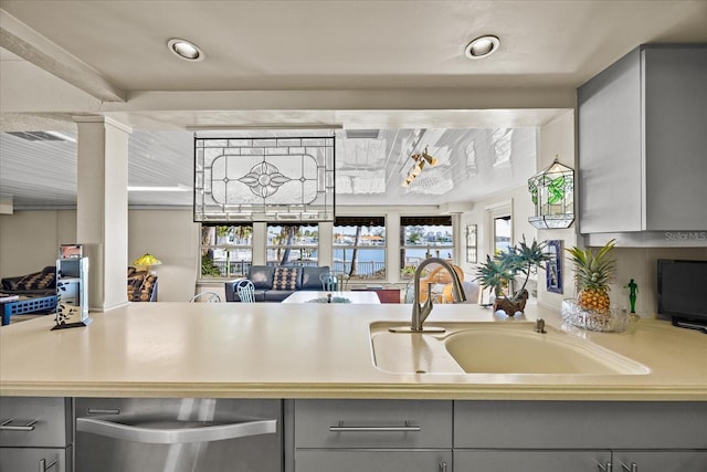 kitchen featuring sink, gray cabinets, and decorative columns