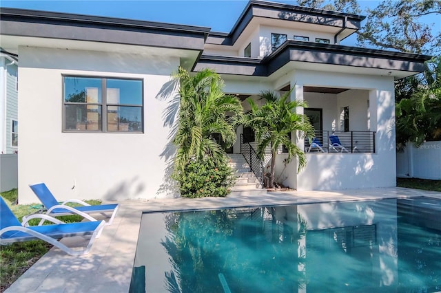 rear view of house featuring a balcony and a patio