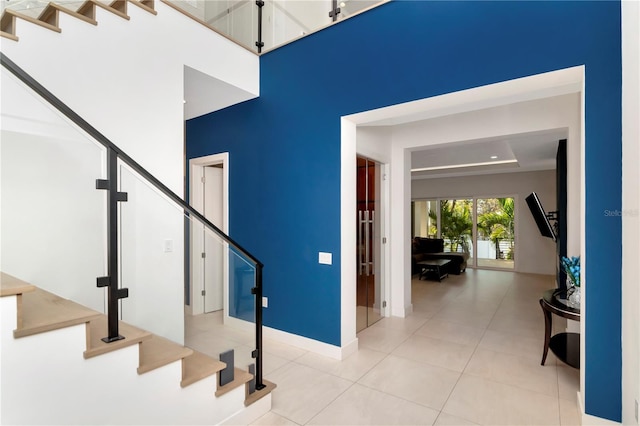 staircase featuring light tile patterned floors and a high ceiling