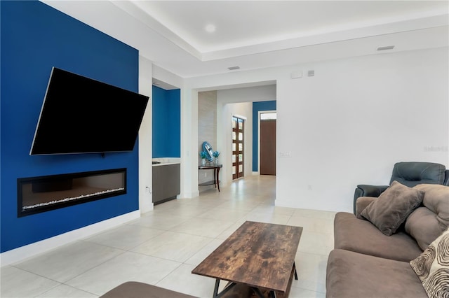 tiled living room featuring a raised ceiling