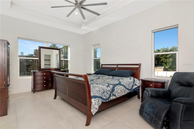 bedroom featuring a raised ceiling, ceiling fan, and light tile patterned floors