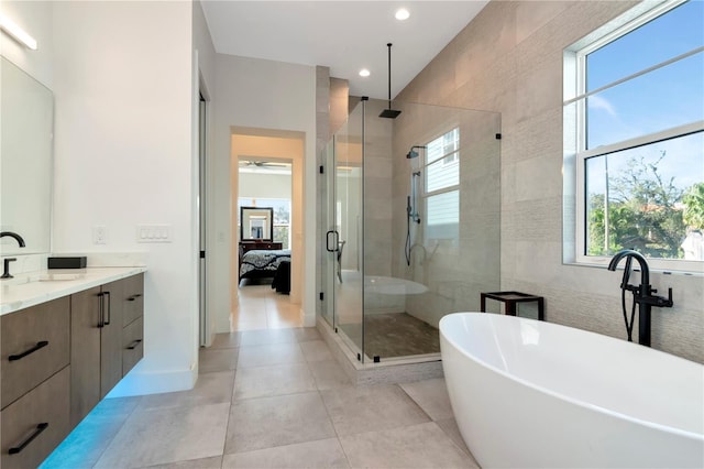 bathroom with vanity, tile patterned floors, shower with separate bathtub, and tile walls