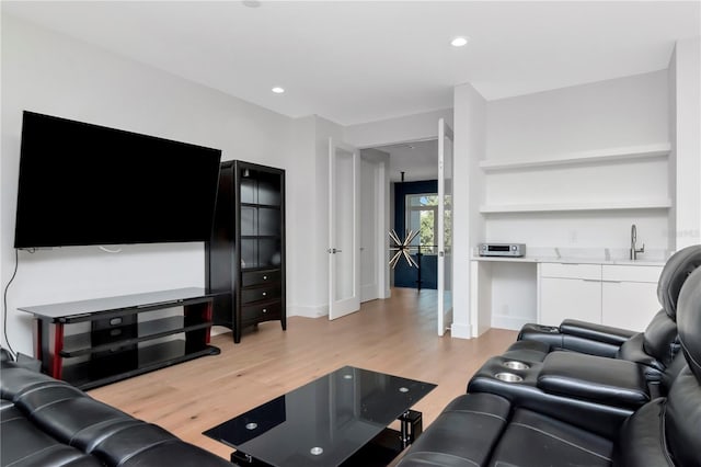 living room featuring sink and light hardwood / wood-style flooring