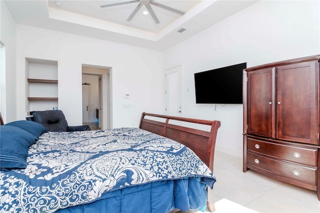 bedroom with a raised ceiling, light tile patterned floors, ceiling fan, and a high ceiling