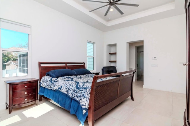 tiled bedroom featuring a raised ceiling and ceiling fan