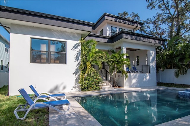 back of house featuring a patio and a fenced in pool