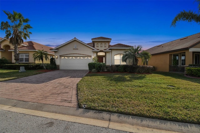 view of front of property with a garage and a lawn