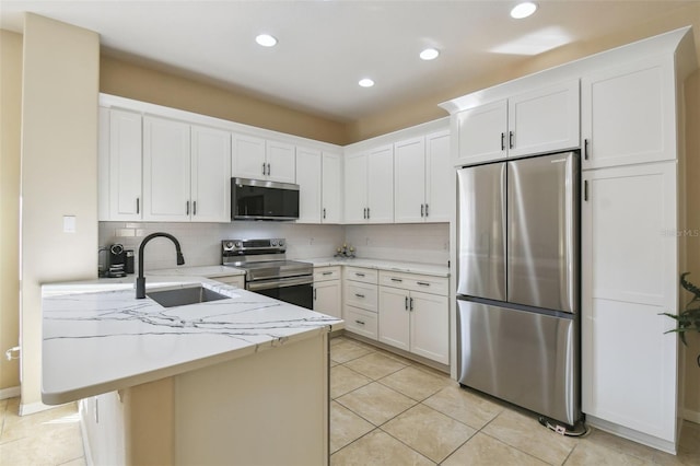 kitchen with sink, white cabinetry, light stone counters, appliances with stainless steel finishes, and backsplash