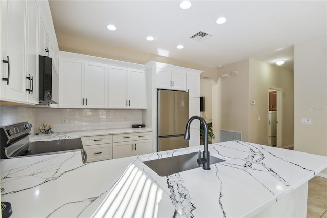 kitchen featuring white cabinetry, appliances with stainless steel finishes, sink, and light stone counters