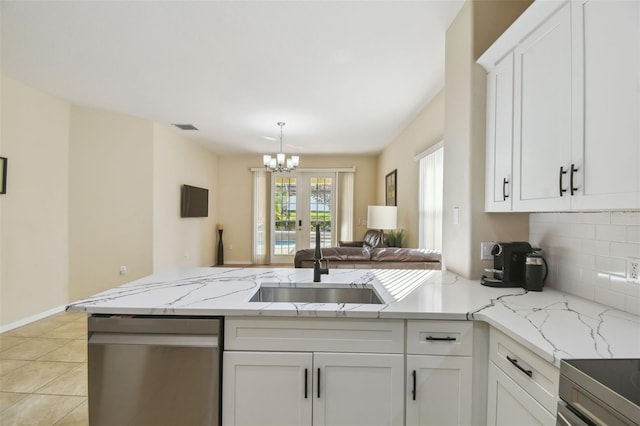 kitchen with white cabinetry, sink, backsplash, and light stone counters