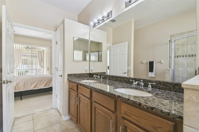 bathroom featuring tile patterned floors, vanity, and a shower with door