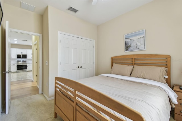 carpeted bedroom with ceiling fan and a closet