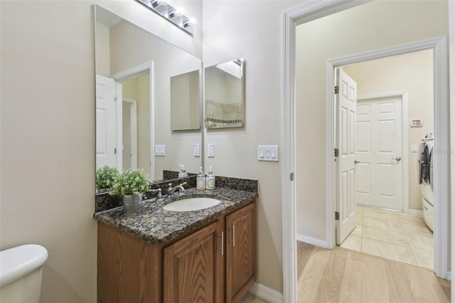 bathroom featuring washer / clothes dryer, vanity, tile patterned floors, and toilet