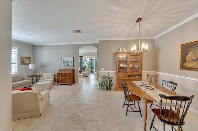 dining space featuring ornamental molding and a notable chandelier