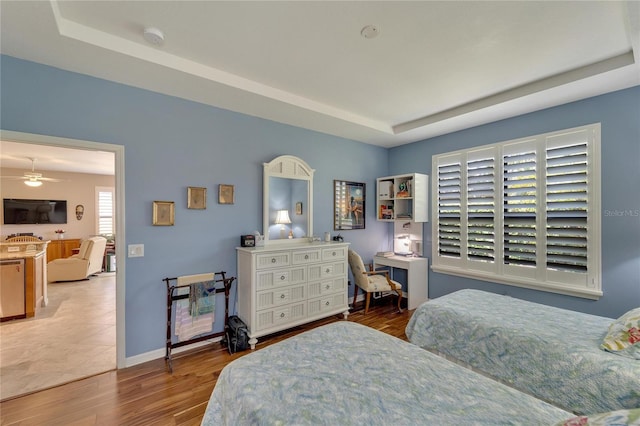 bedroom featuring a tray ceiling and wood-type flooring