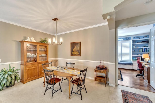 tiled dining area featuring ornamental molding and a chandelier