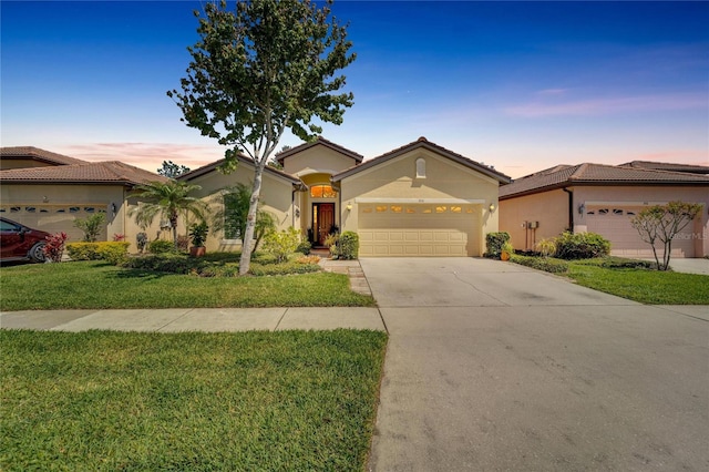 mediterranean / spanish-style house with a yard and a garage