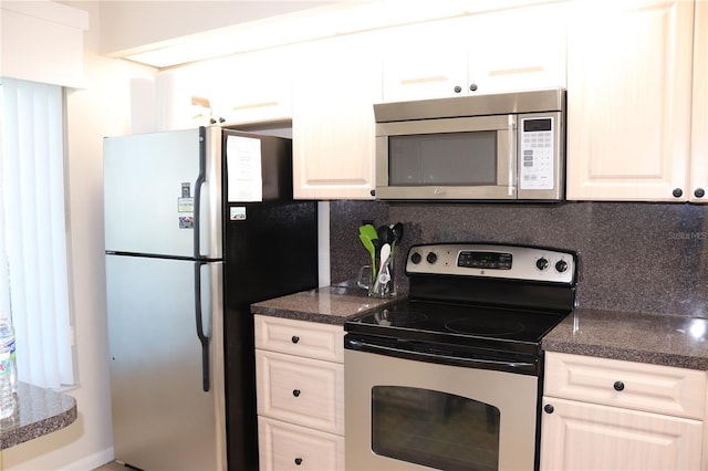 kitchen featuring stainless steel appliances, dark stone counters, and decorative backsplash