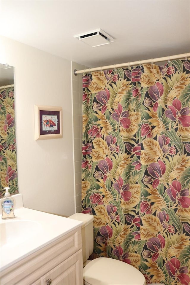 bathroom featuring walk in shower, vanity, and toilet