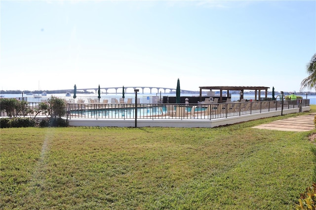 view of pool with a water view, a yard, and a pergola