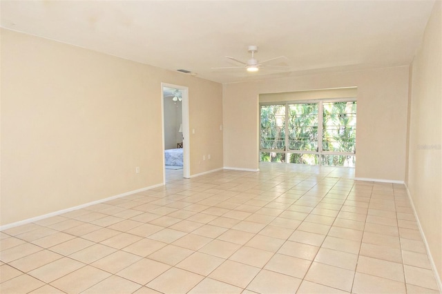 tiled empty room featuring ceiling fan