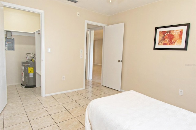 tiled bedroom featuring a spacious closet and water heater