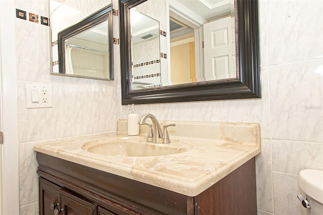 bathroom with vanity, tile walls, and toilet