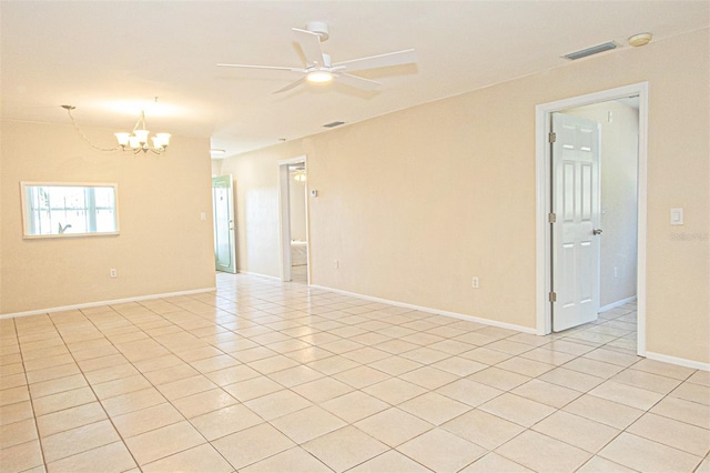 tiled empty room with ceiling fan with notable chandelier