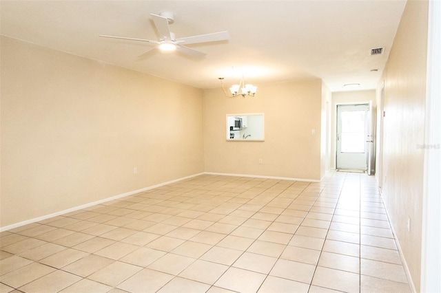 unfurnished room featuring ceiling fan with notable chandelier and light tile patterned floors