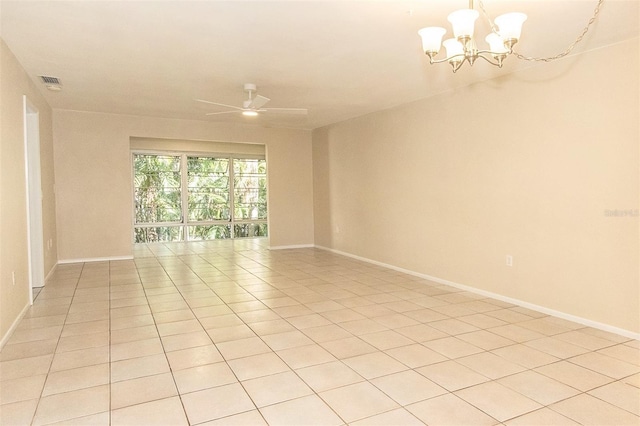 tiled empty room with ceiling fan with notable chandelier