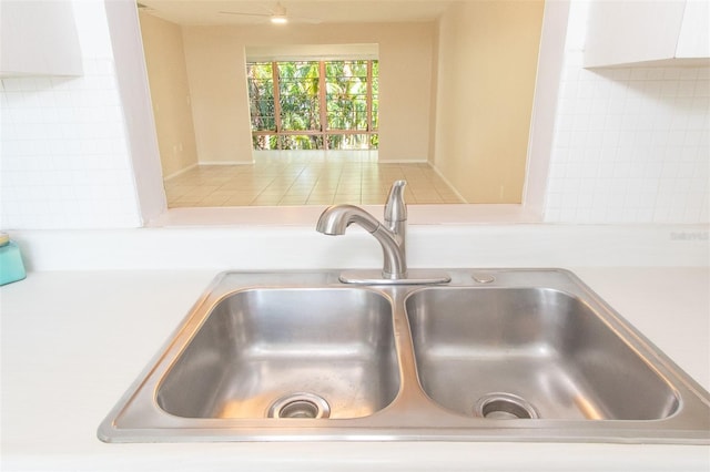 interior details featuring white cabinetry, sink, and decorative backsplash