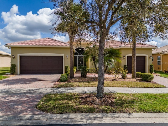 view of front of property with a garage, decorative driveway, and stucco siding