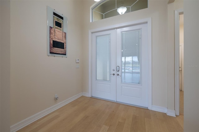 doorway to outside with french doors, light wood-style flooring, and baseboards