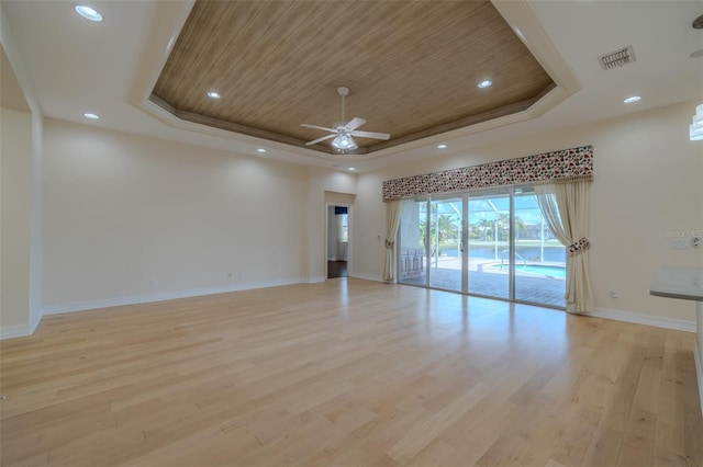 unfurnished room with light wood-style flooring, wooden ceiling, a raised ceiling, and visible vents