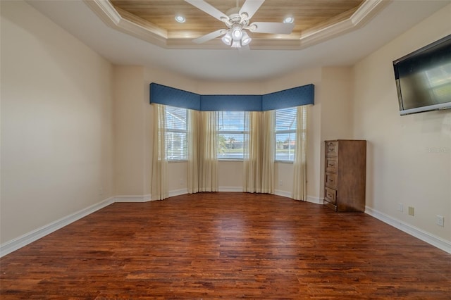 unfurnished room featuring ornamental molding, wood finished floors, and a raised ceiling