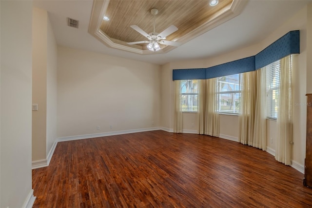 spare room featuring a ceiling fan, a tray ceiling, visible vents, and wood finished floors