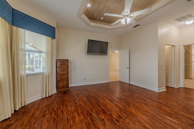 unfurnished bedroom with baseboards, visible vents, a raised ceiling, and wood finished floors