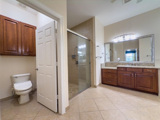 bathroom featuring toilet, a stall shower, vanity, and tile patterned floors