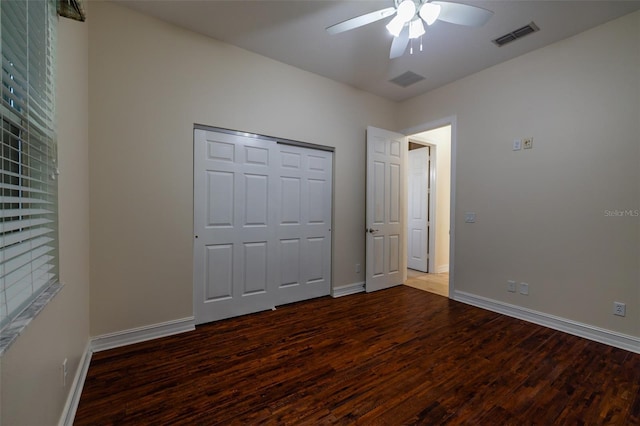 unfurnished bedroom with a ceiling fan, visible vents, baseboards, and wood finished floors