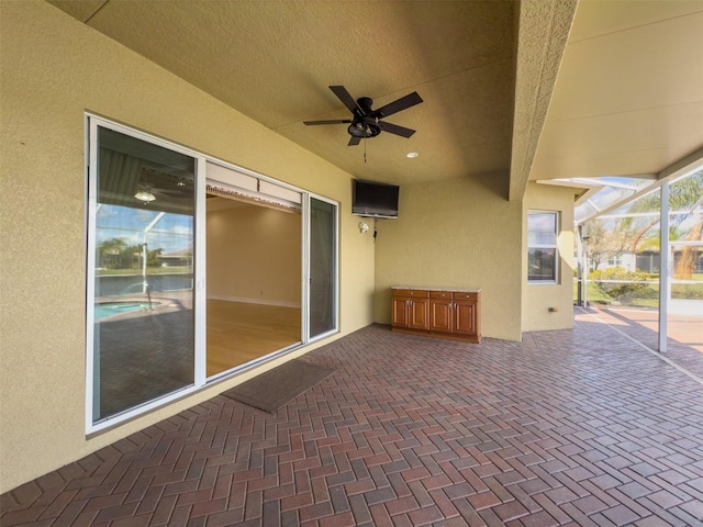 view of patio / terrace featuring ceiling fan and a lanai