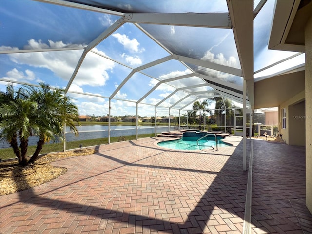 view of pool with a water view, glass enclosure, a pool with connected hot tub, and a patio