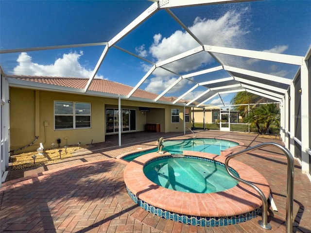 view of pool with a patio area, a lanai, and a pool with connected hot tub