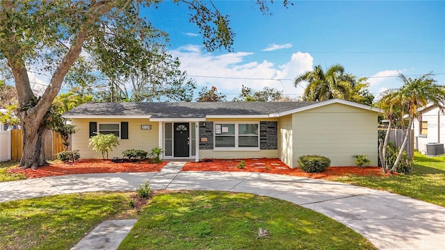 ranch-style house featuring central AC and a front lawn