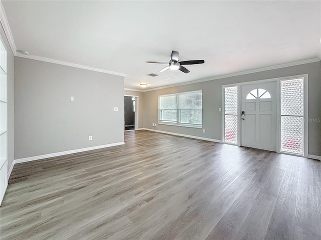 unfurnished living room featuring wood-type flooring, ornamental molding, and ceiling fan