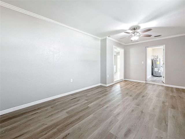 empty room featuring ceiling fan, ornamental molding, electric water heater, and light hardwood / wood-style flooring