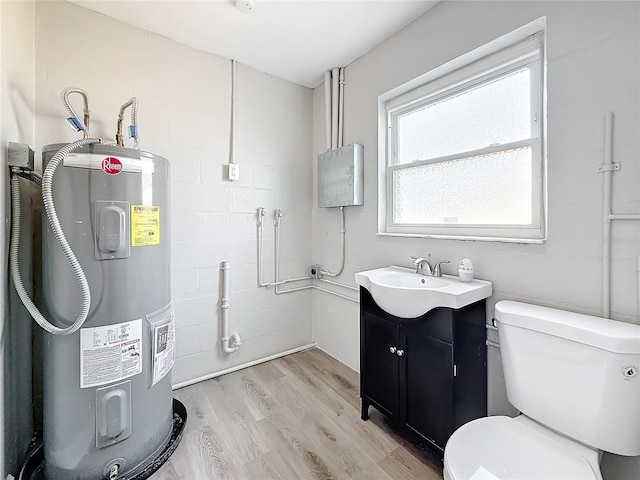 interior space with vanity, hardwood / wood-style floors, water heater, and toilet