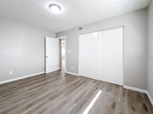 unfurnished bedroom featuring a closet and light wood-type flooring