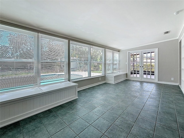 unfurnished sunroom featuring vaulted ceiling, a healthy amount of sunlight, and french doors