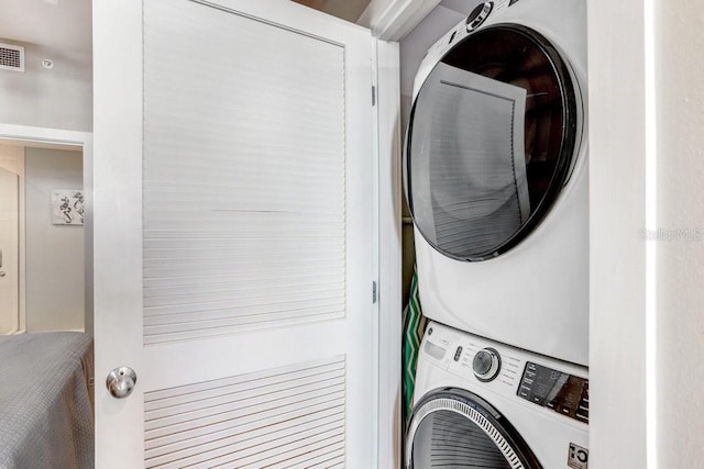 washroom featuring stacked washer / drying machine