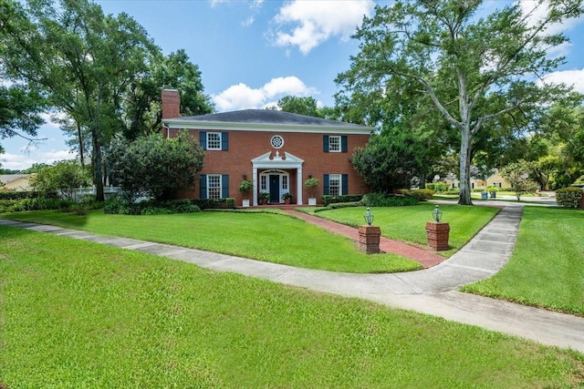 colonial inspired home with a front lawn